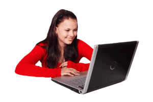 A smiling young lady sitting at laptop