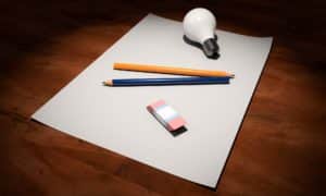 A blank piece of paper with pencils, lightbulbs and eraser