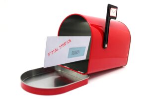 A red metal mail box opened with a letter sticking out that says Final Notice