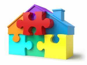 A variety of different color puzzle pieces making up a house shape