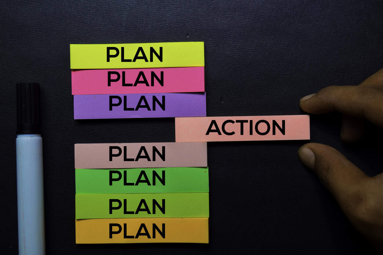 Plan or Action text on sticky notes isolated on Black desk. Mechanism Strategy Concept