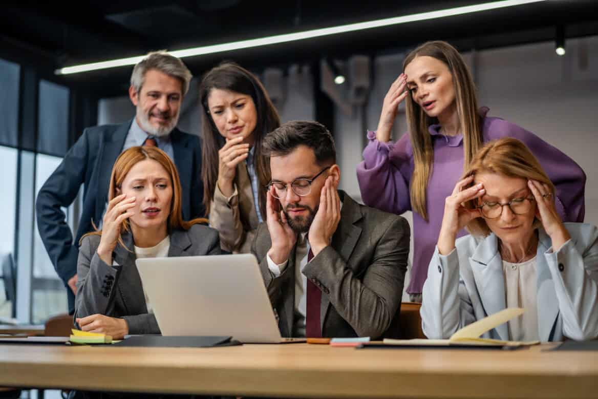 Group of diverse business employees experiencing frustration and work pressure during a difficult moment in the office